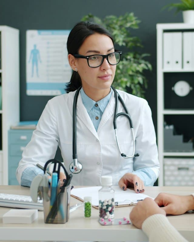 A doctor at her desk consulting with a patient