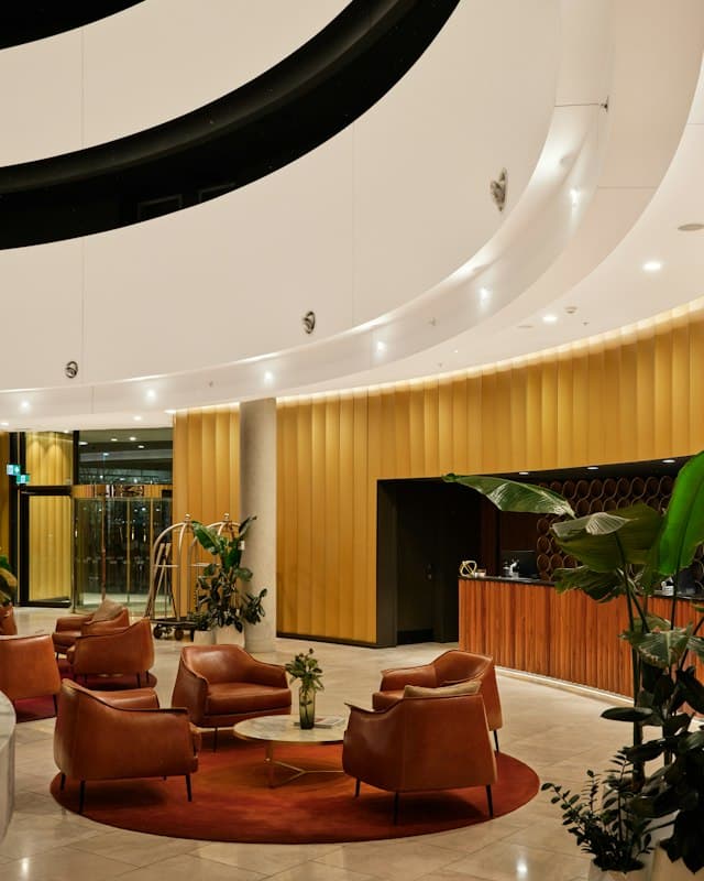 A modern hotel lobby with lounge chairs and a reception desk