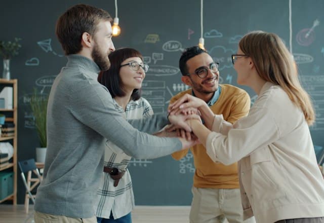 A team joining hands to celebrate a successful launch